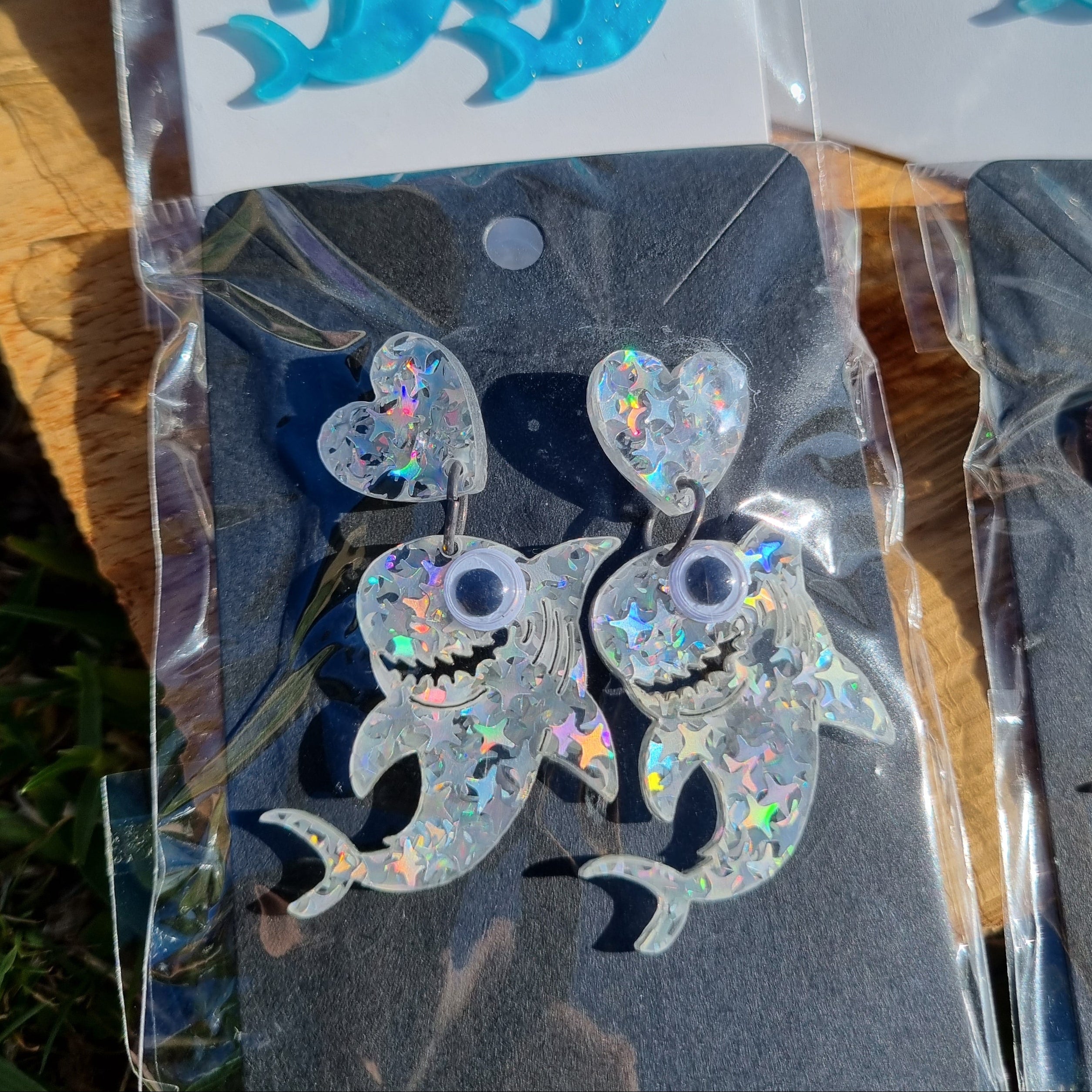 Shark-shaped earrings with googly eyes .